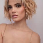 Blonde, wavy bob wig with side-swept bangs and layered texture.